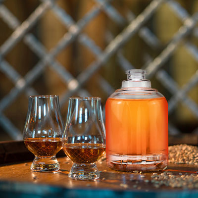 25OZ Bouteille de spiritueux ronde avec un design de panneau droit et une poignée de pistolet à un doigt en verre